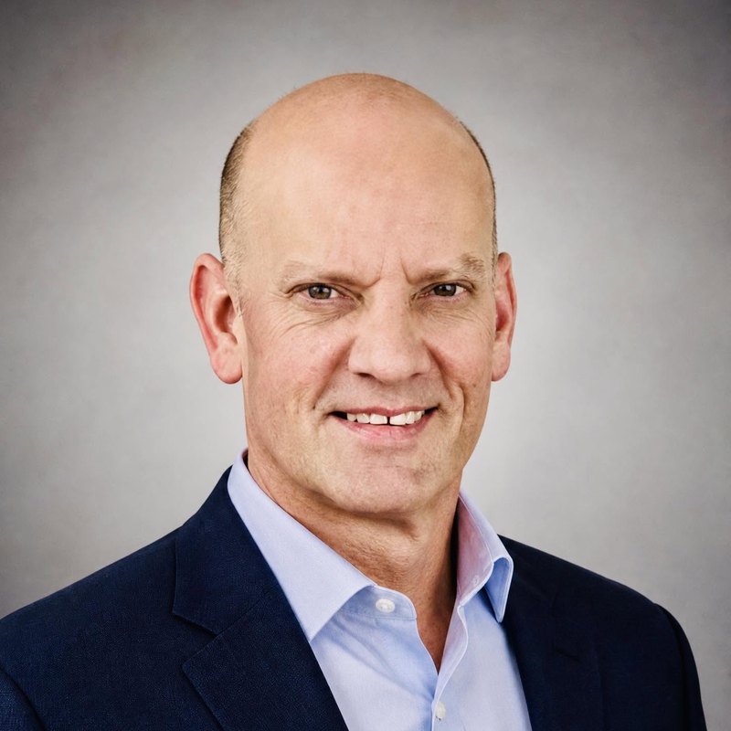 Portrait of author Eric Morris in a navy blazer and light blue shirt
