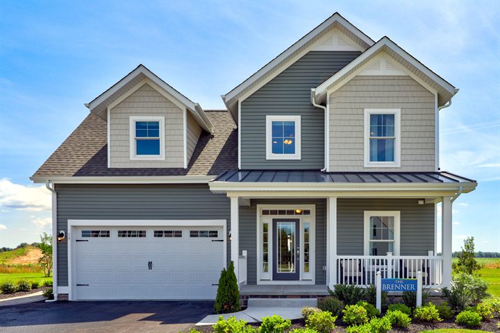 The Brenner at 54 River Run Boulevard: two-story home with gray siding, front porch and two-car garage