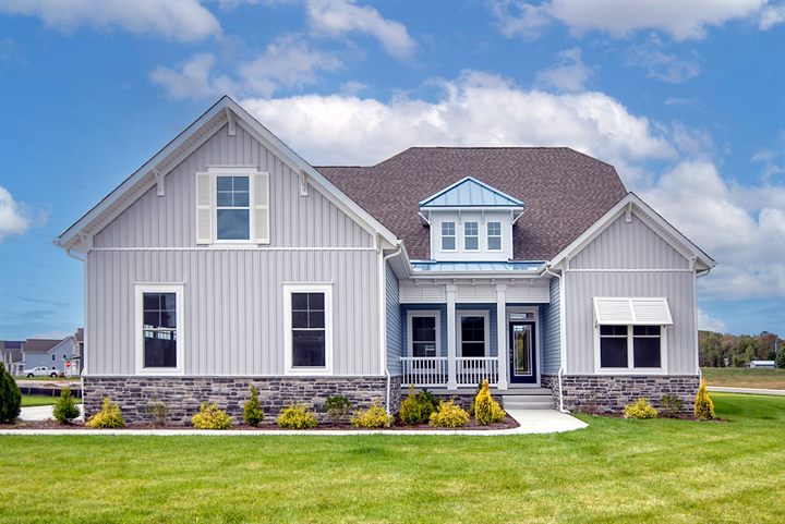 The Whatley at 54 Levee Court: white board-and-batten two-story home with stone accents